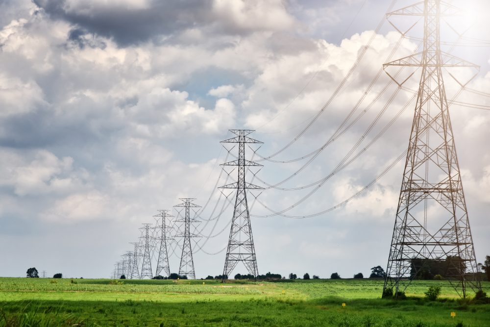 Grid-generated electricity transmitted through high-voltage tower.